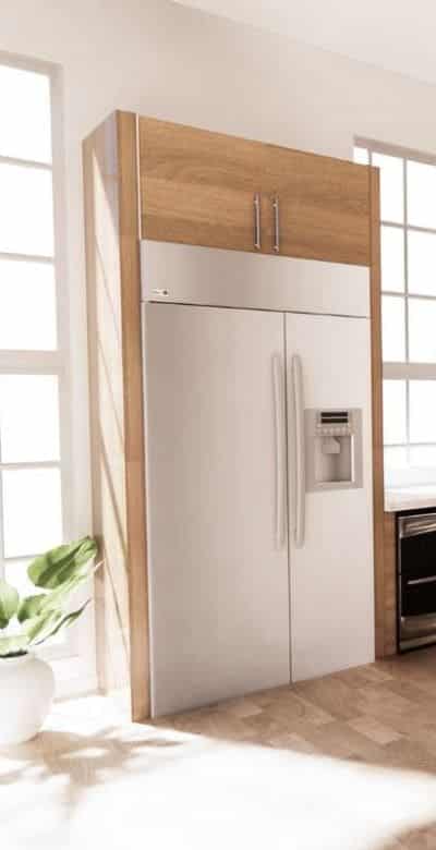 Visión móvil de una cocina de una construcción con criterios pasivos en la que existen varios elementos en madera y un frigorífico encastrado.